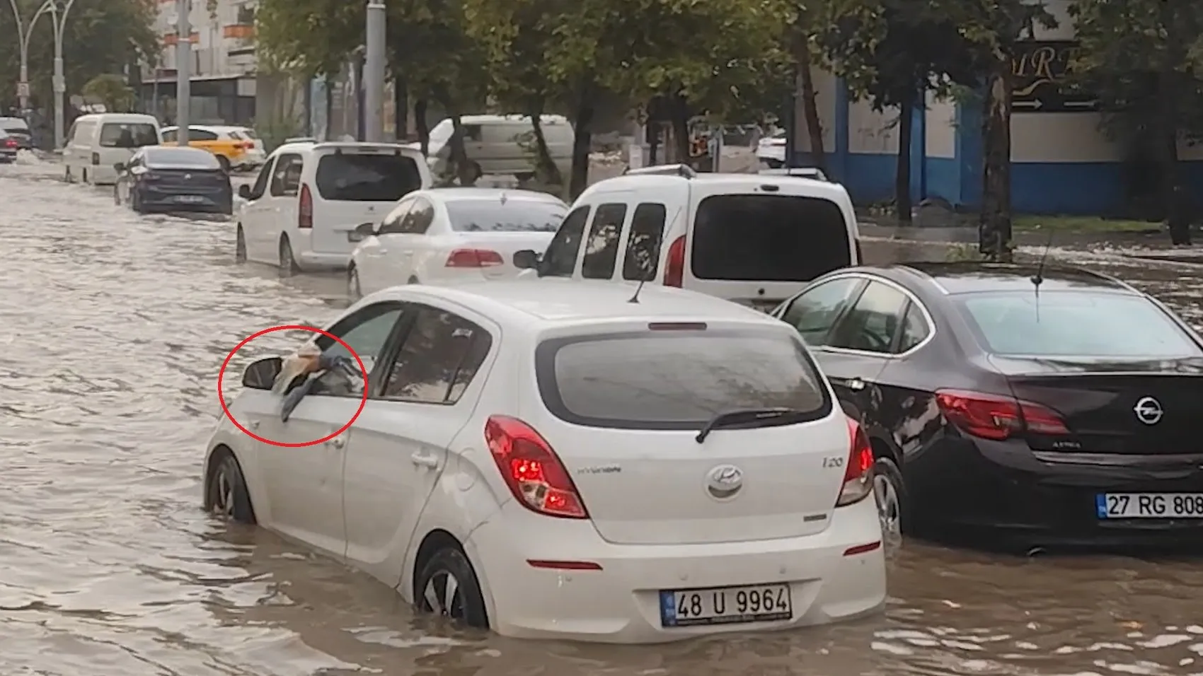 Diyarbakır'da sağanak yağış sonrası ilginç anlar: Otomobiline dolan suyu bardakla boşalttı