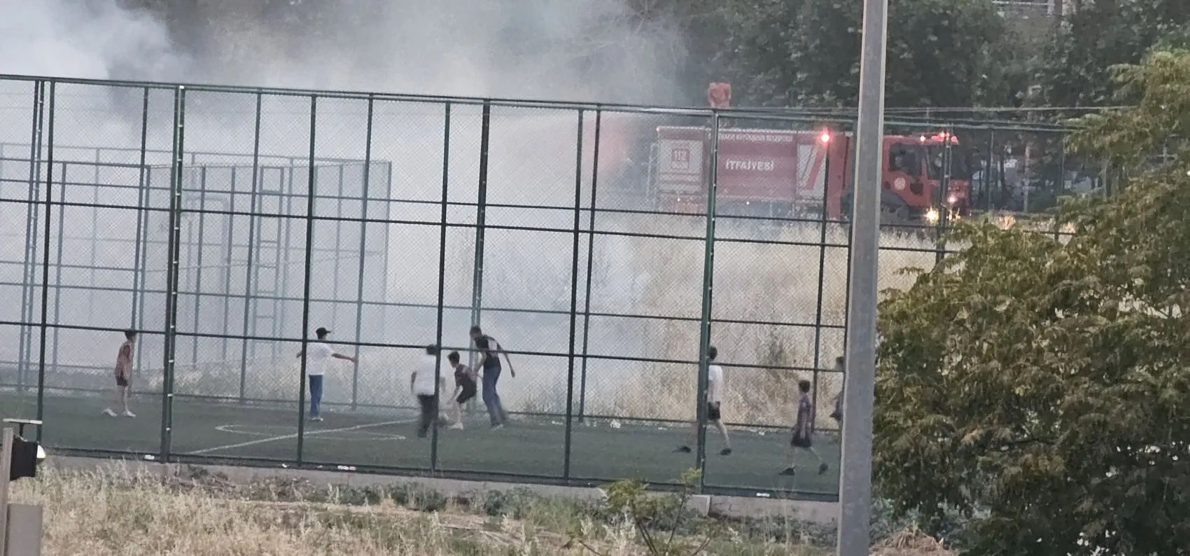 Bağlar'da otluk alanda yükselen alevlere aldırış etmediler Çocuklar maçlarına devam etti
