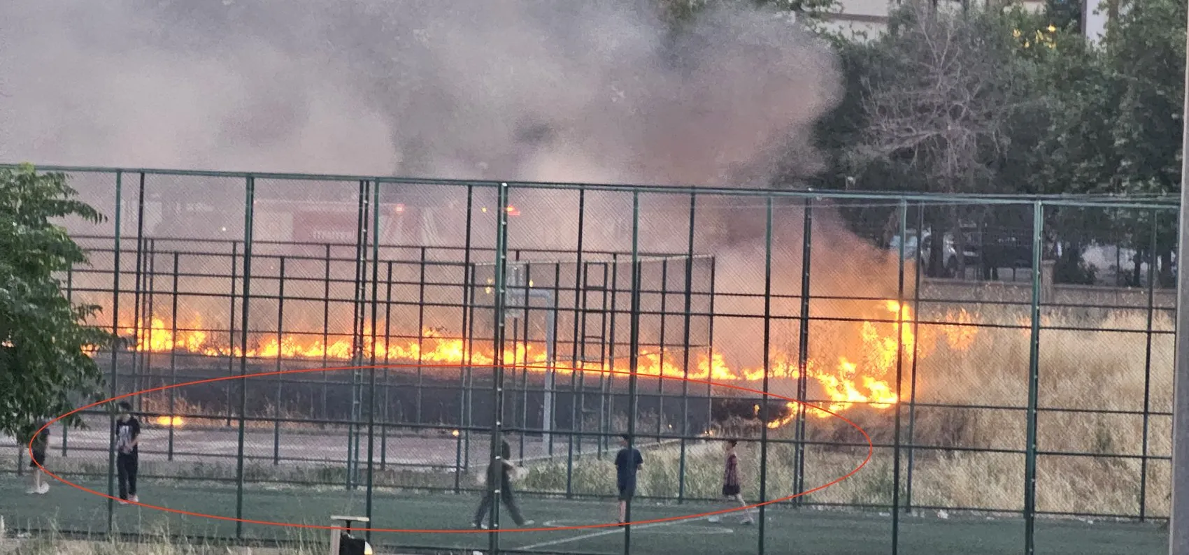 Bağlar'da otluk alanda yükselen alevlere aldırış etmediler Çocuklar maçlarına devam etti